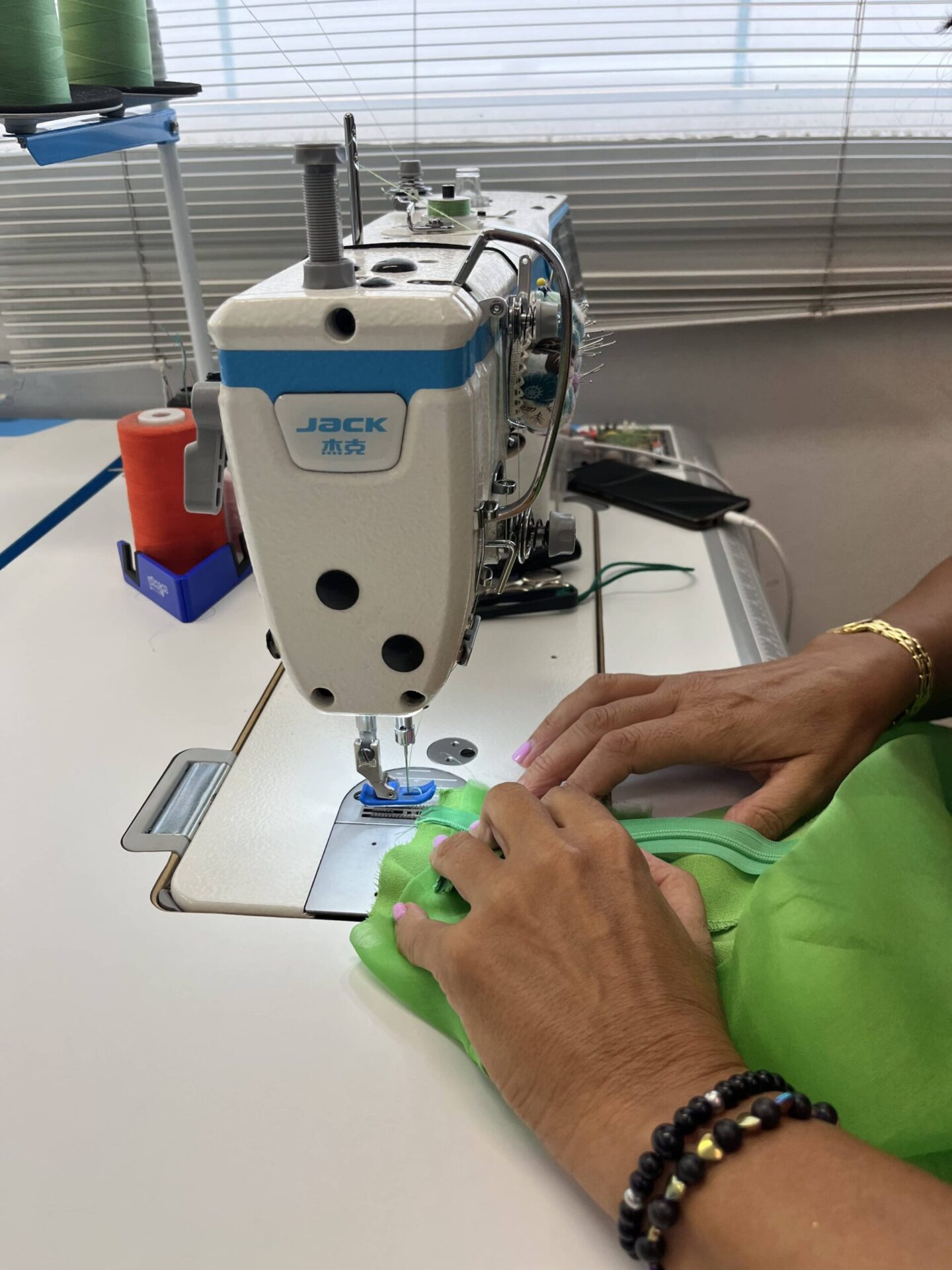 Manos cosiendo un vestido con una máquina de coser